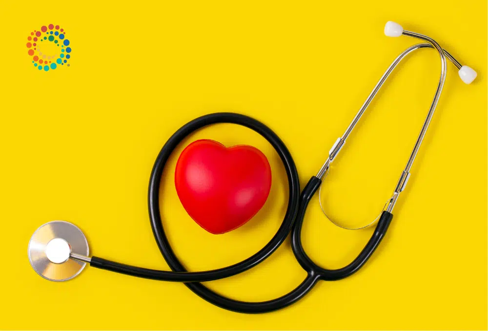 Stethoscope wrapped around atoy heart on a yellow background